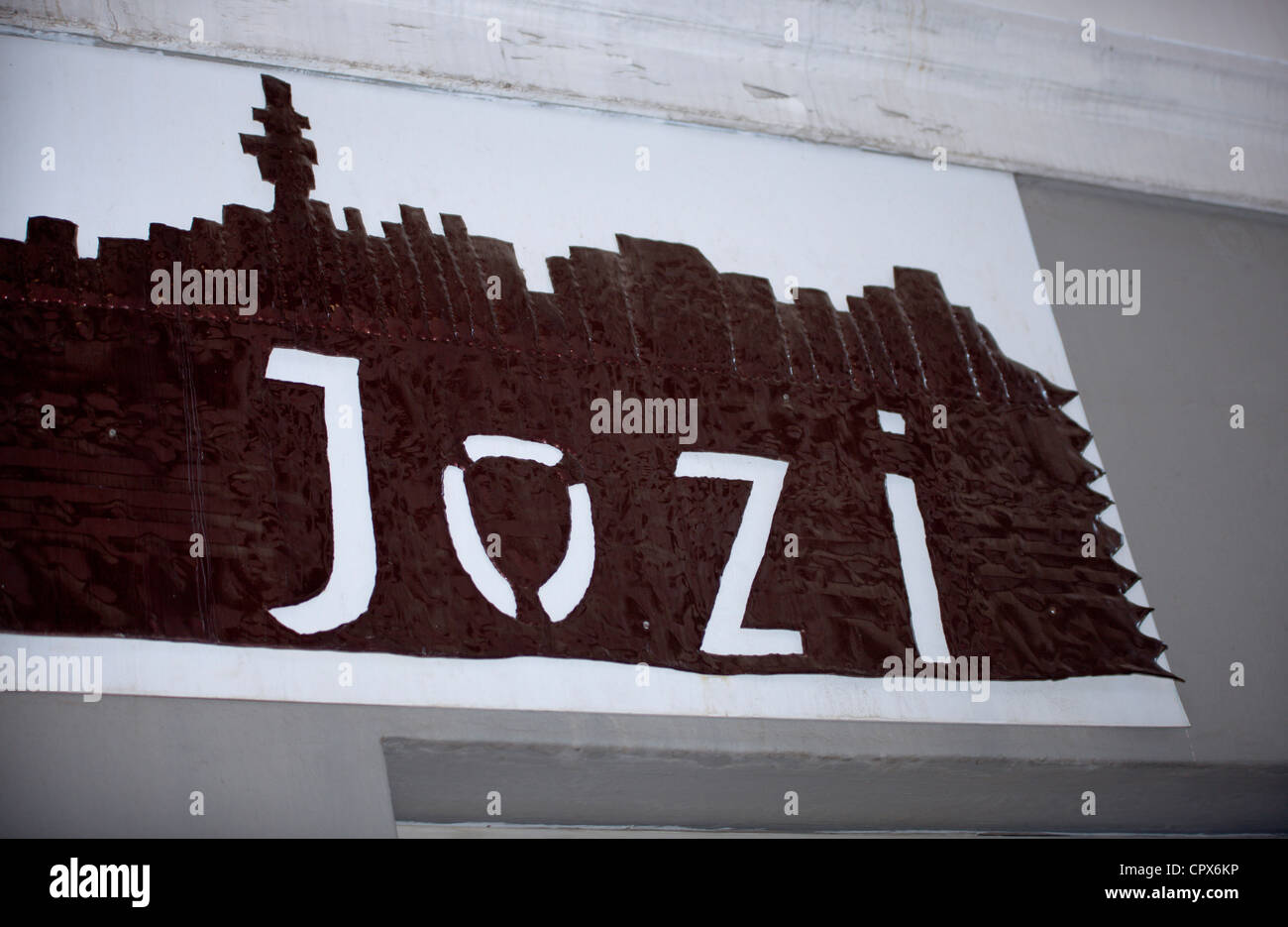 The word 'Jozi' cut out of brown fabrics on a white surface Stock Photo