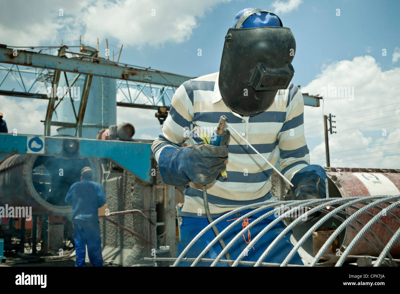 Black factory worker welding steel frame Stock Photo