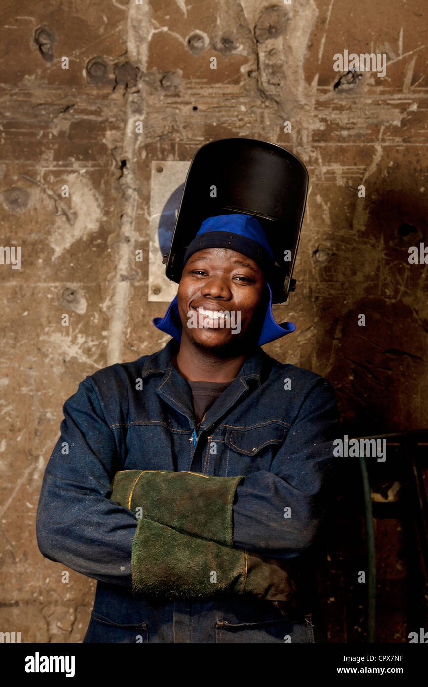 Factory worker posing in welding helmet, magnet factory, Gauteng, South Africa Stock Photo