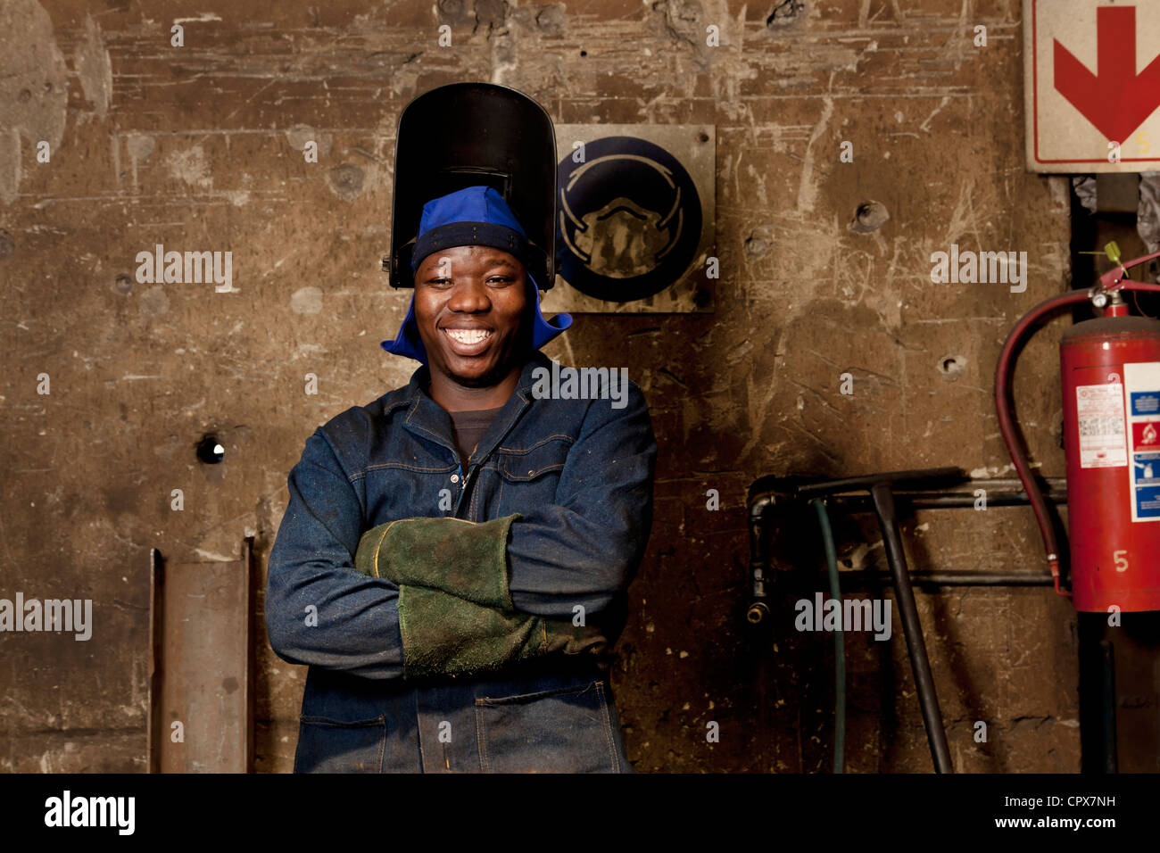 Factory worker posing in welding helmet, magnet factory, Gauteng, South Africa Stock Photo