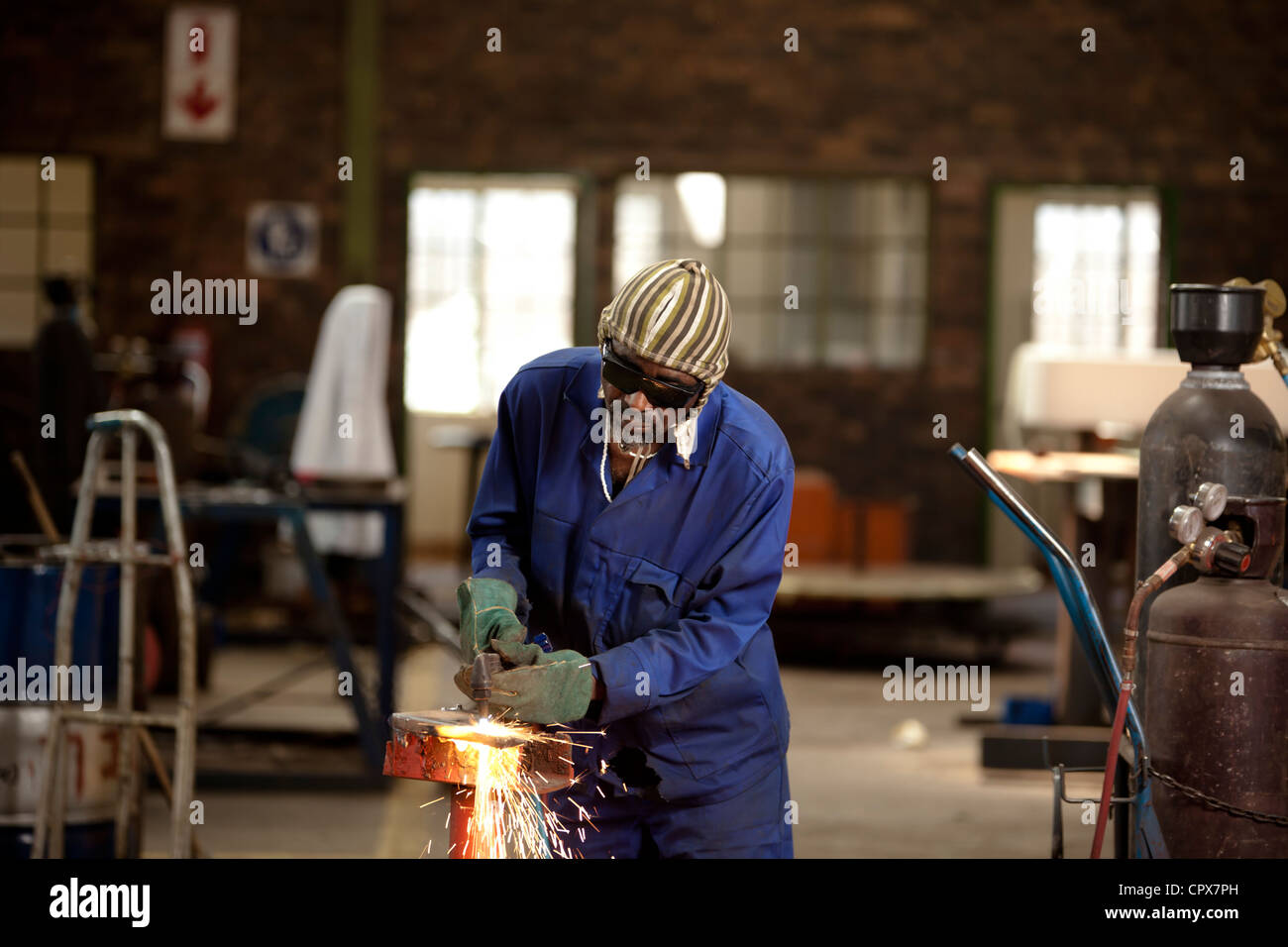 Factory worker operating blow torch, magnet factory, Gauteng, South Africa Stock Photo