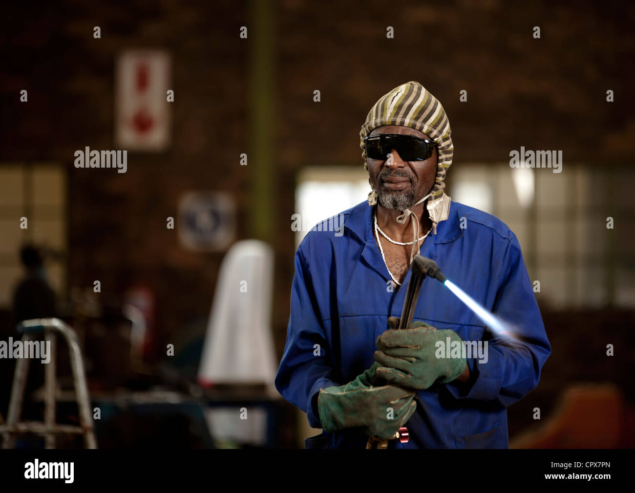 Factory worker posing with blow torch, magnet factory, Gauteng, South Africa Stock Photo