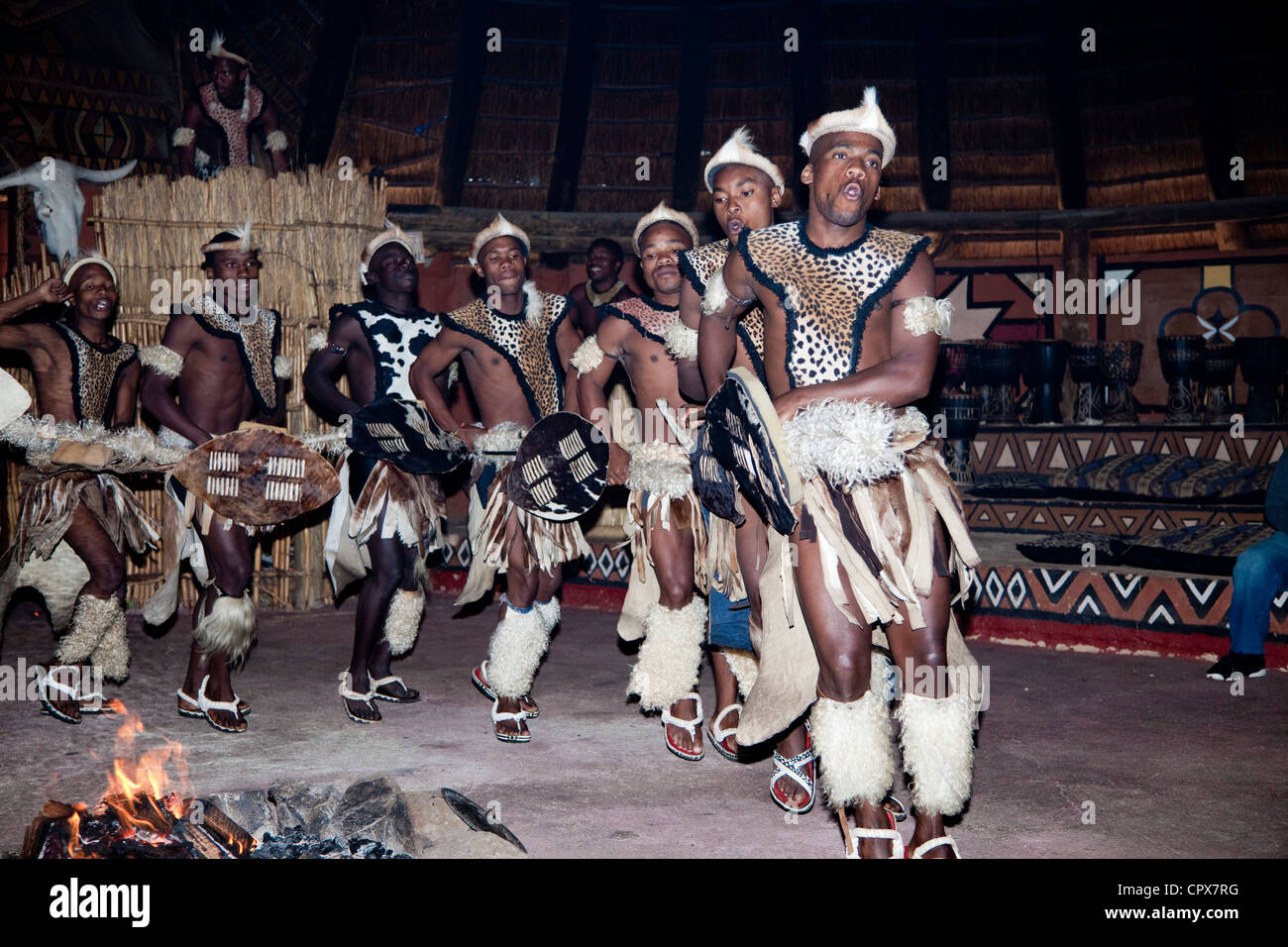 A group of traditional African male dancers dance around a fire Stock Photo