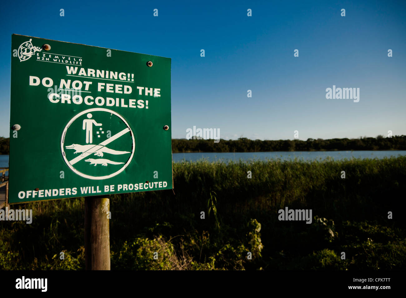 Closeup of a signpost instruction the public not to feed crocodiles Stock Photo