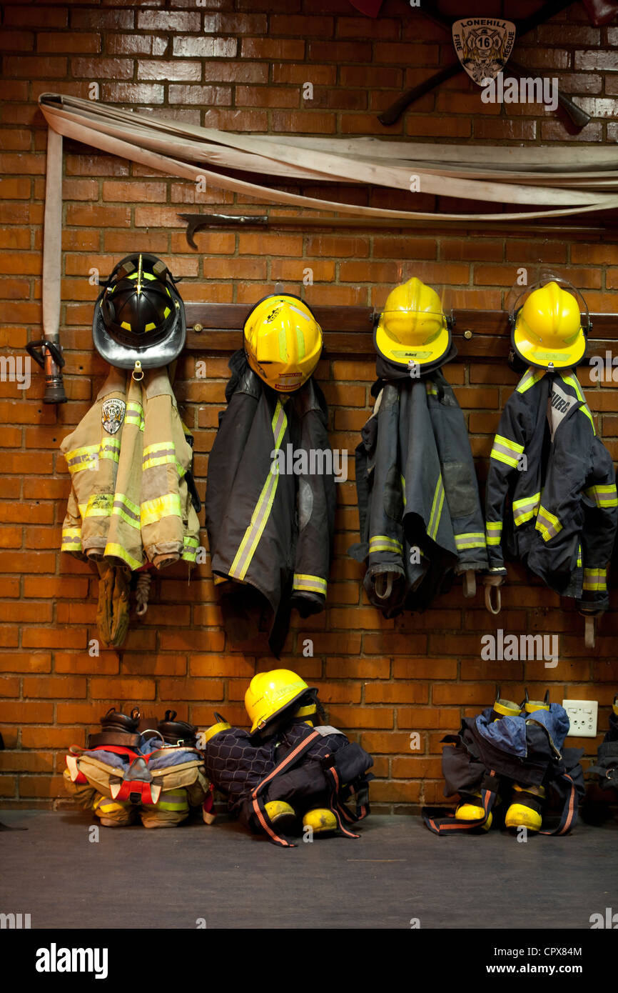Firemen uniforms hanging up on a wall Stock Photo