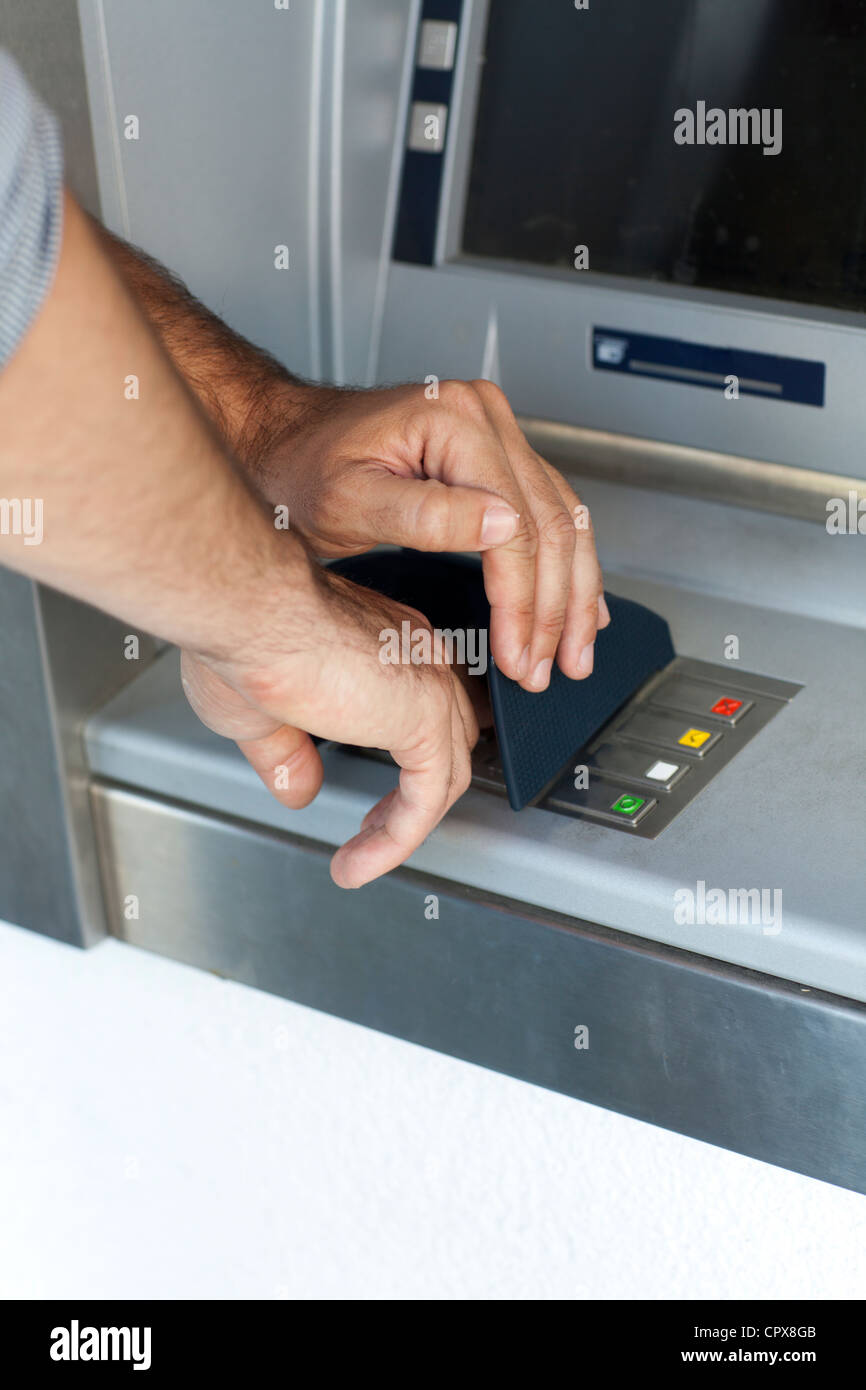 man puts PIN number in the ATM Stock Photo