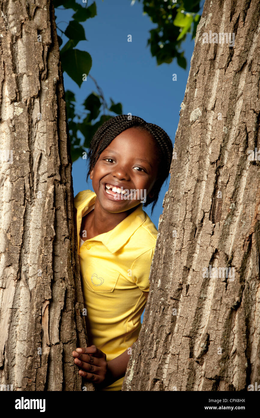 Portrait of a little girl standing in a tree Stock Photo - Alamy