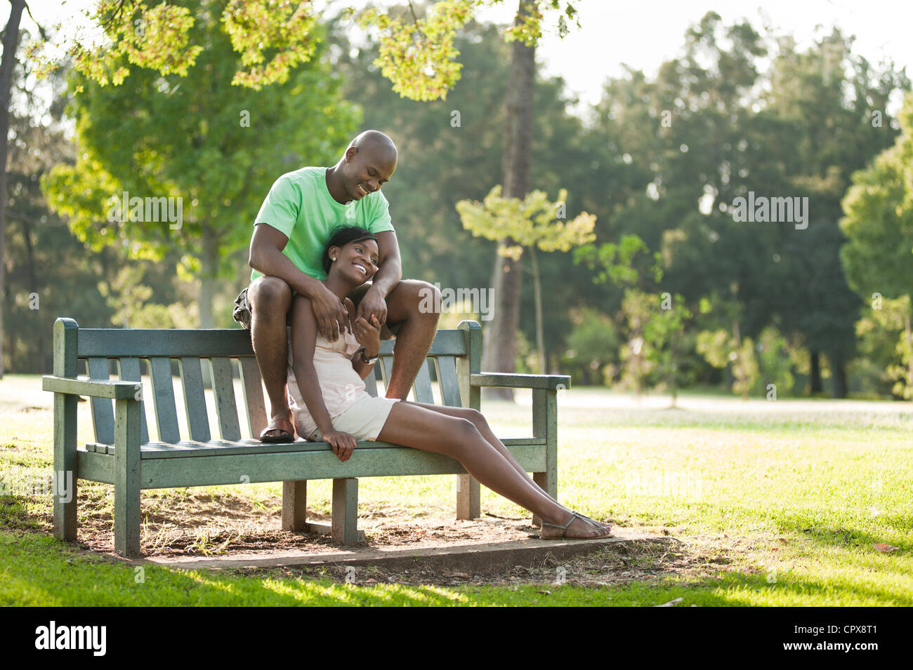 A young African couple sits together in a park Stock Photo - Alamy