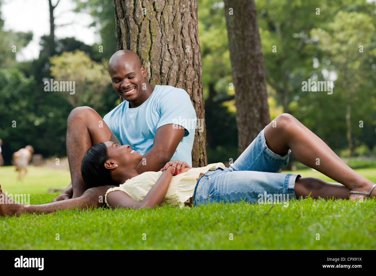 Young African couple sitting together in a park Stock Photo