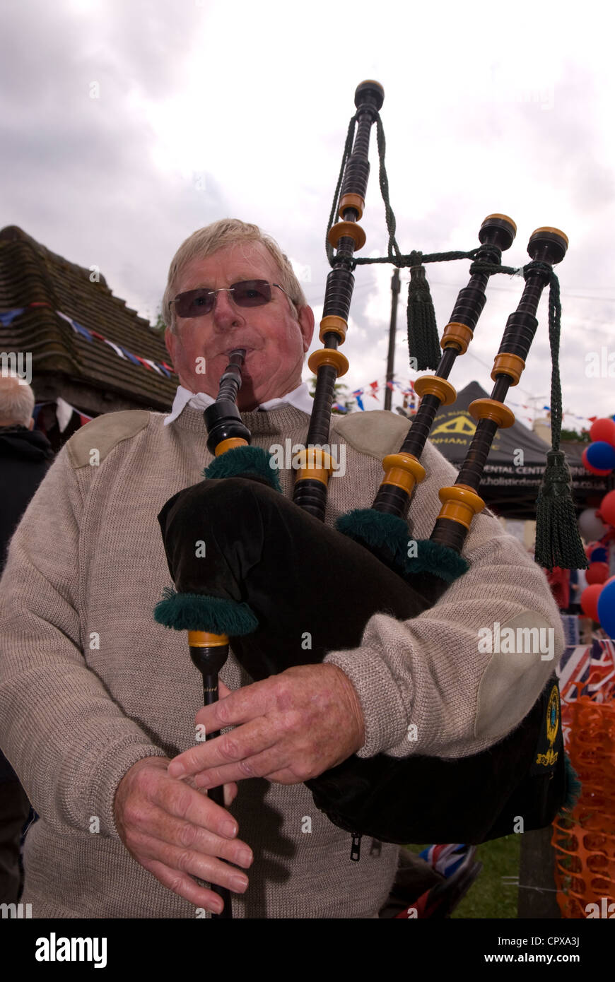 Man playing the bagpipes at the celebrations for the Queen's Diamond Jubilee, Rowledge Village Stock Photo