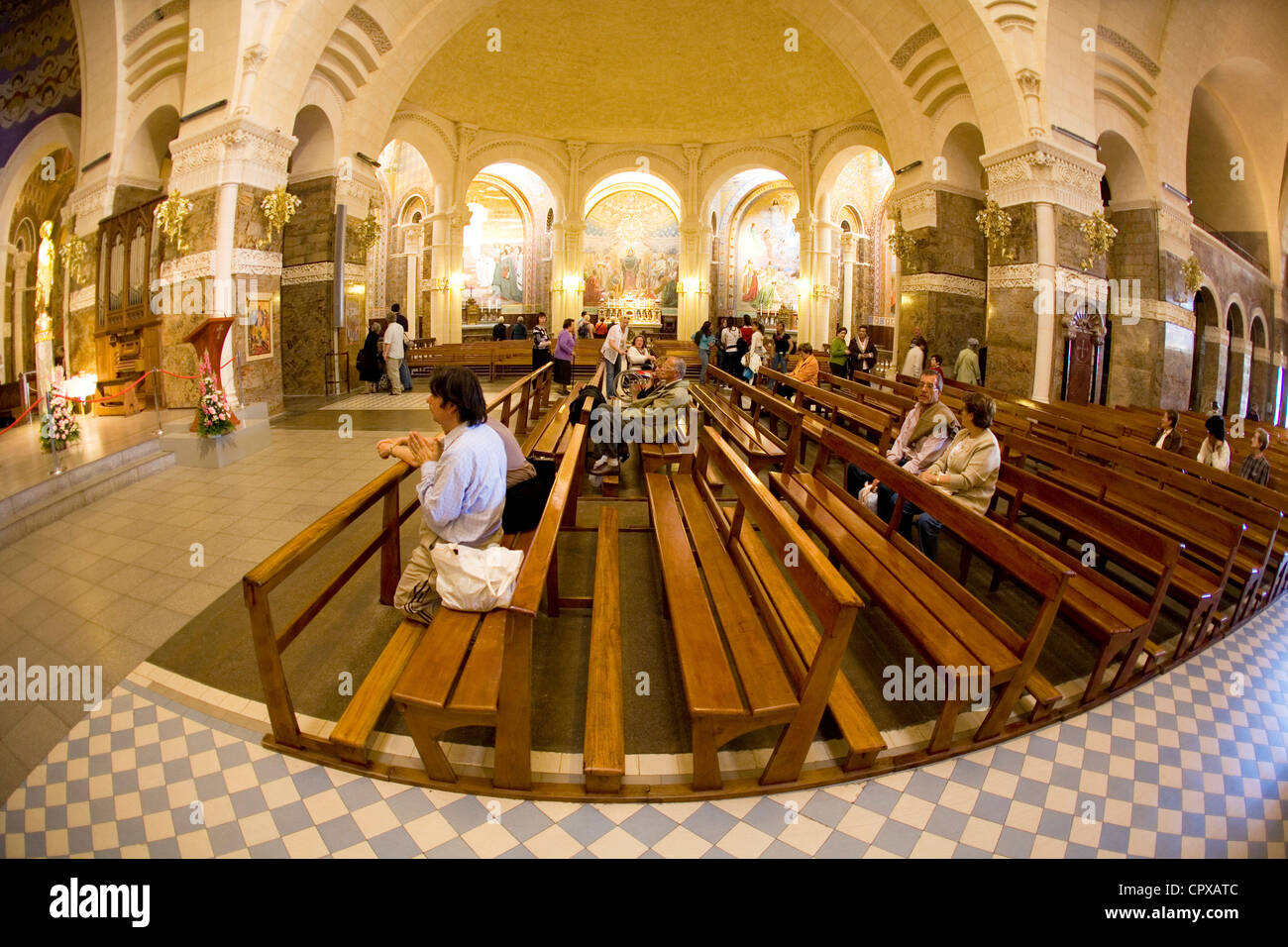 Christian pilgrims inside the Rosary Basilica, Lourdes, Midi-Pyrenees, France Stock Photo