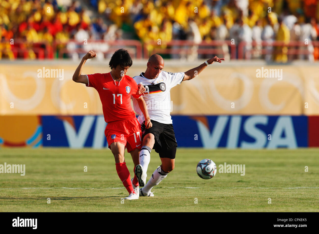 Suk Young Yun of South Korea (L) passes the ball ahead of Dani Schahin of Germany (R) during a FIFA U-20 World Cup match. Stock Photo