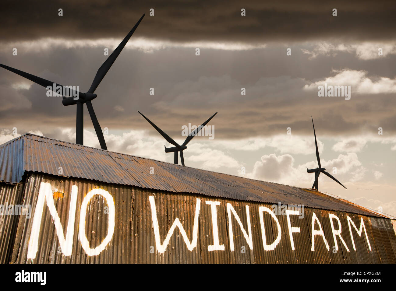 composite of a wind farm and an anti wind farm protest on a barn outside Carlisle, Cumbria, UK. Stock Photo