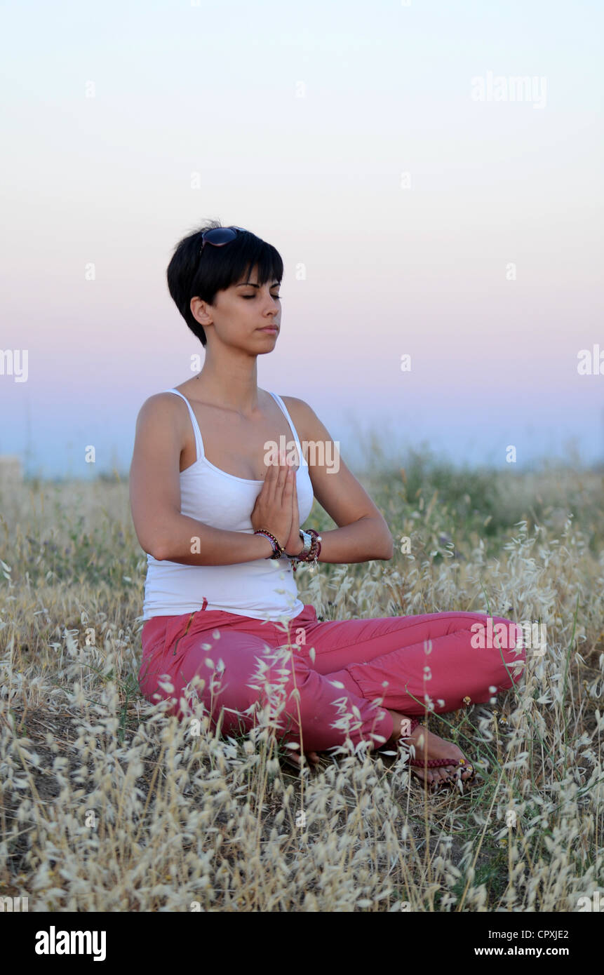 Attractive Short Haired Woman Practices Yoga In Nature Stock Photo