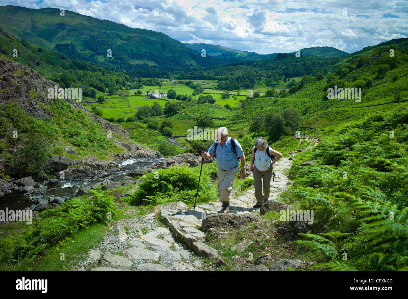 Tourists hill climbing on nature trail in lakeland countryside at Easedale in the Lake District National Park, Cumbria, UK Stock Photo
