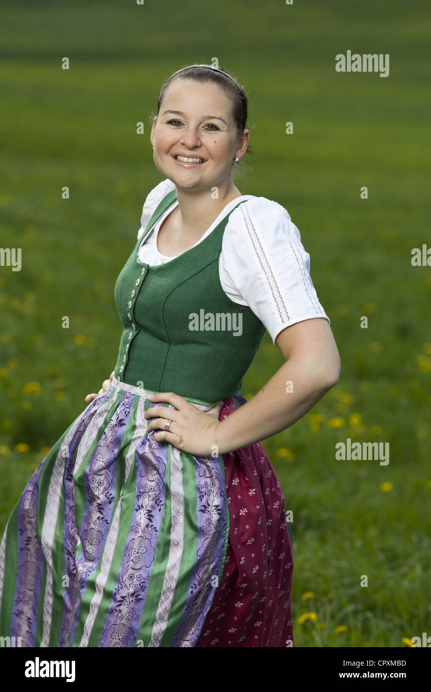 Young woman with Austrian traditional clothes in a green meadow Stock Photo