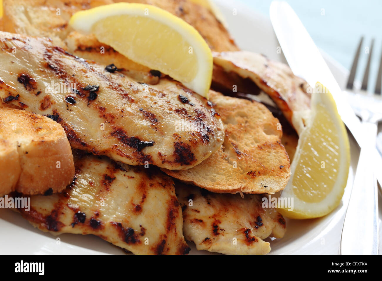 Grilled lemon chicken with garlic bread,Closeup. Stock Photo