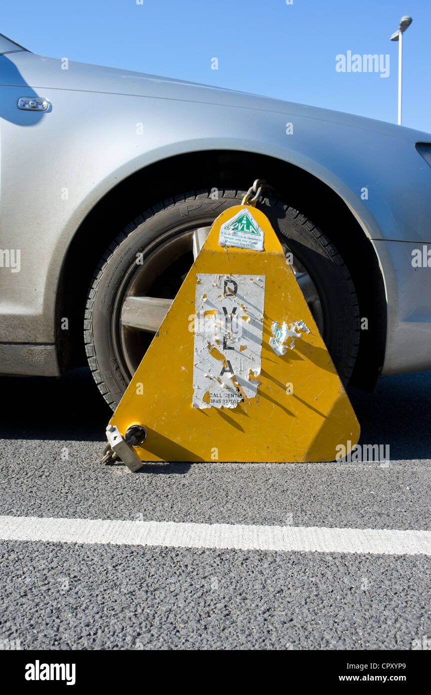 Untaxed car clamped in public car park Stock Photo