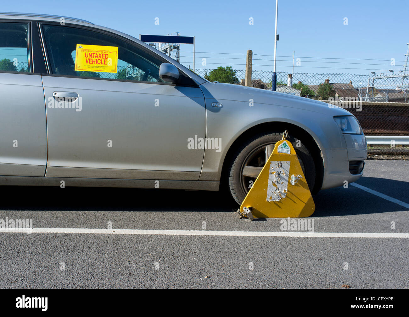Untaxed car clamped in public car park Stock Photo