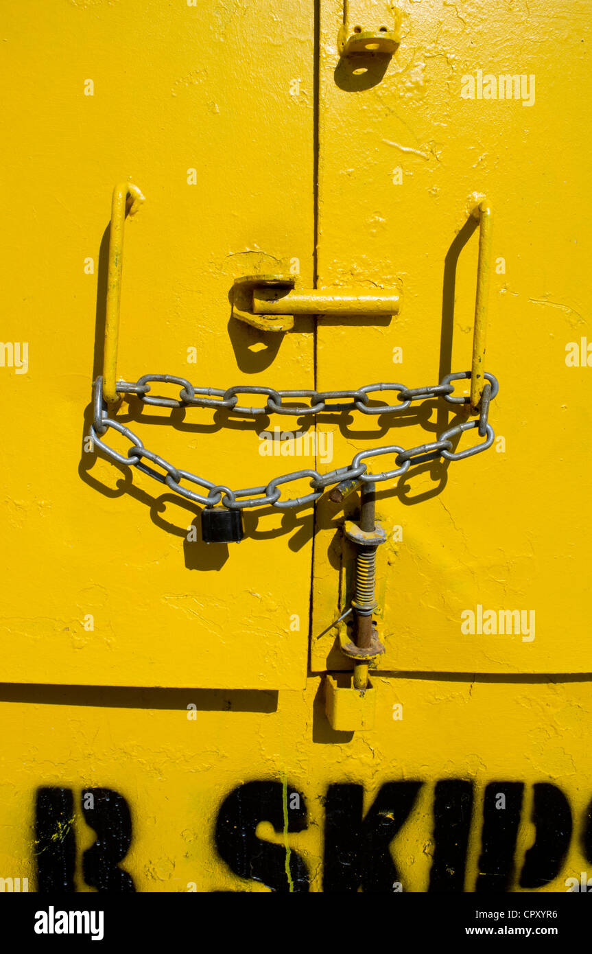 padlocked and chained steel door on a skip Stock Photo