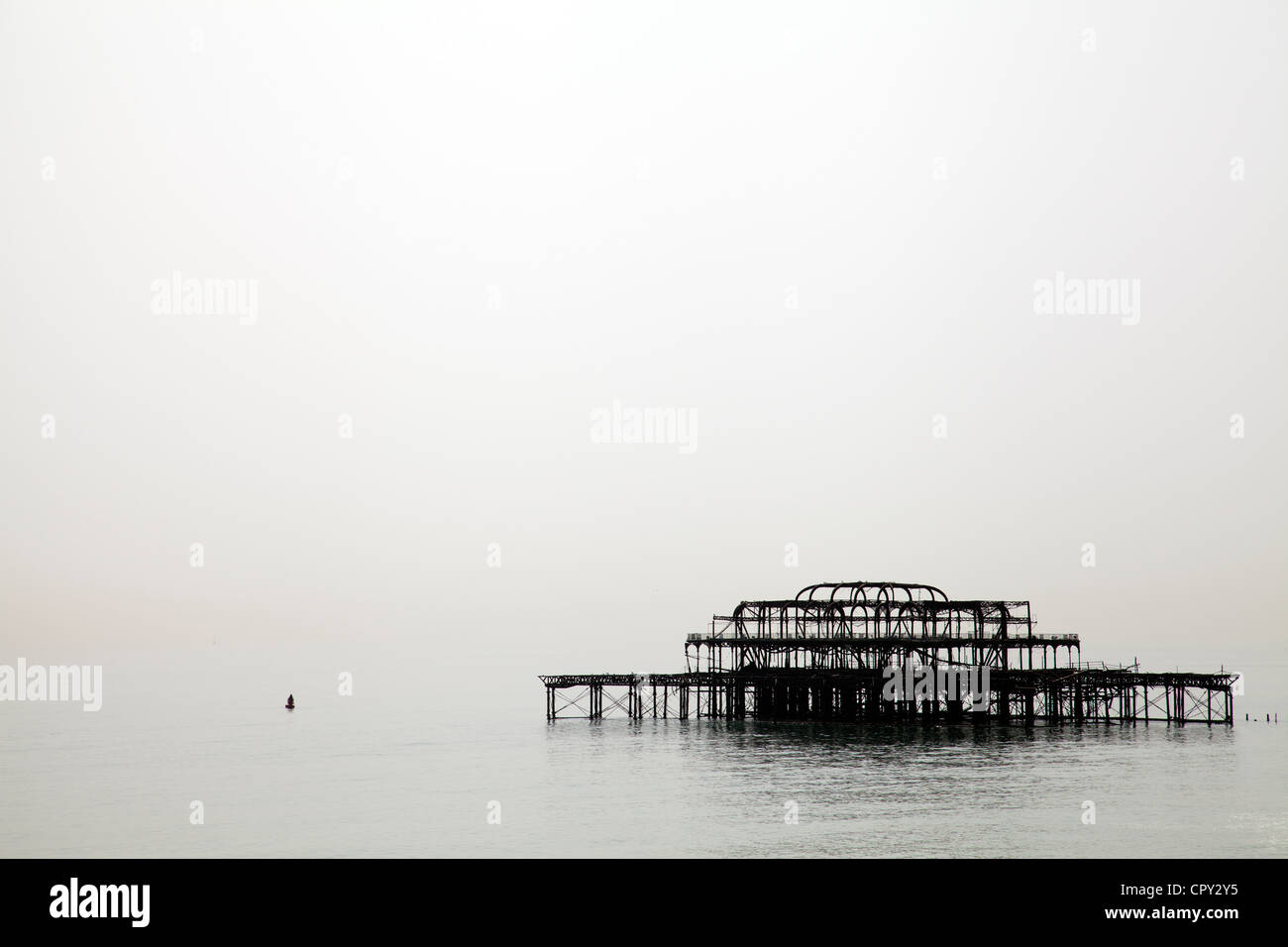 Burnt out West Pier in Brighton in summer Haze - UK Stock Photo