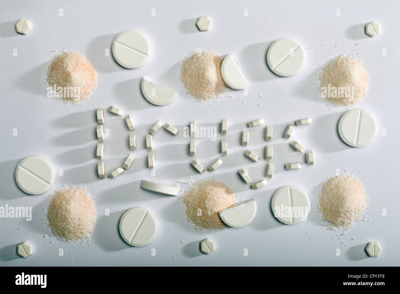 Pills and powders used to spell the word drugs. Stock Photo