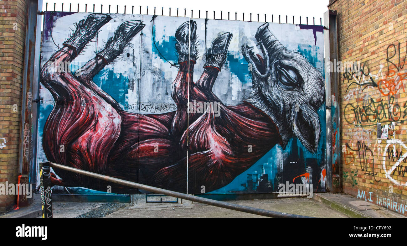 Graffiti art of a giant flayed pig by Belgian street artist Roa on metal gates in Buxton Street London England Europe Stock Photo
