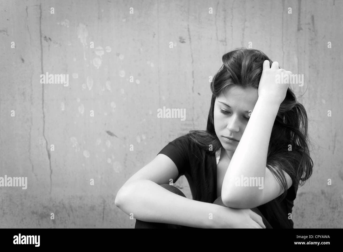 Outdoor portrait of a sad teenage girl looking thoughtful about troubles, monochrome photo Stock Photo