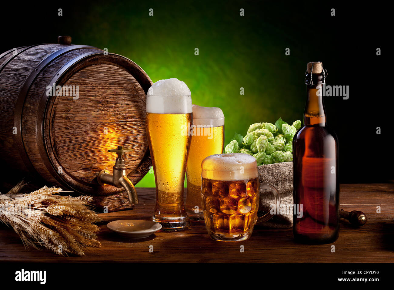 Beer barrel with beer glasses on a wooden table. The dark green