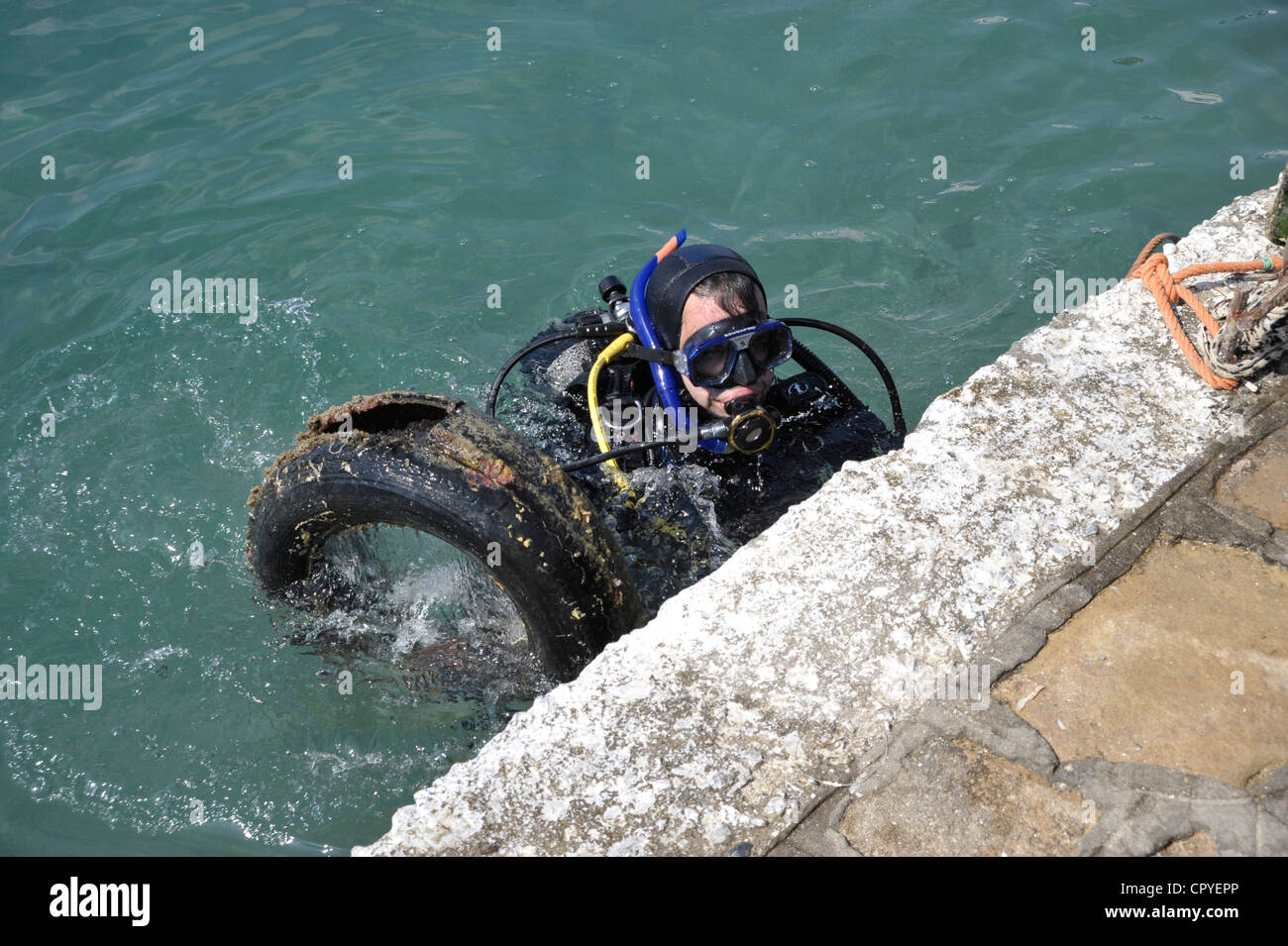 Diver taking old tired out of the sea. Stock Photo