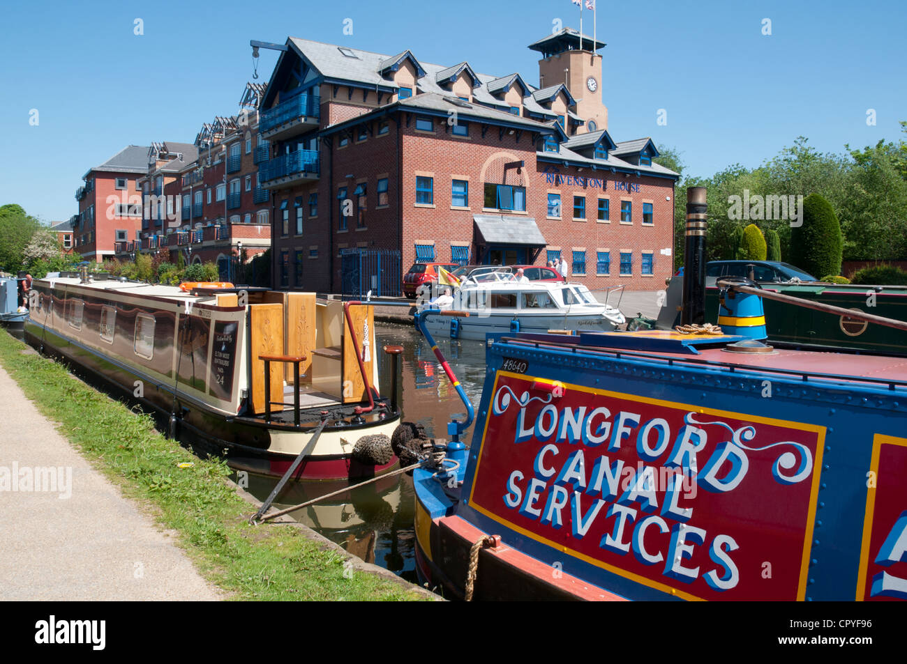 Narrowboats and apartments on the Bridgewater Canal at Sale Waterside, Cheshire, England, UK Stock Photo