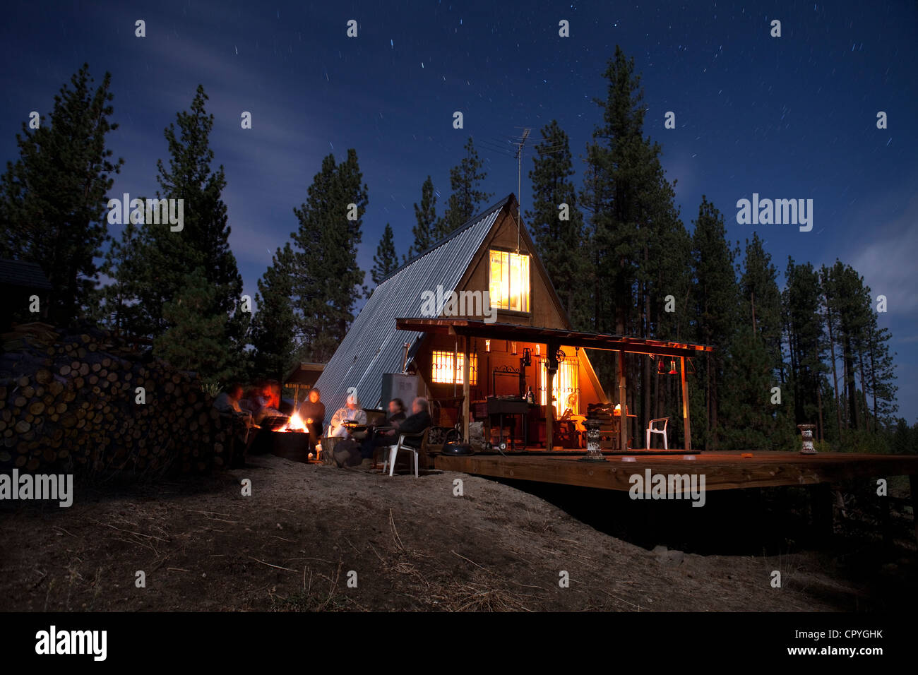 Friends Sit Fireside Surrounded By Sequoia National Forest Stock