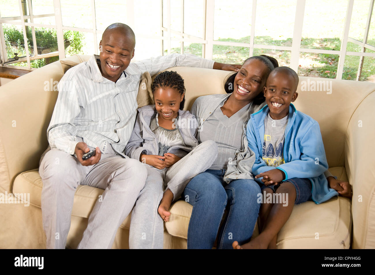 Young African family sit together on a couch Stock Photo - Alamy