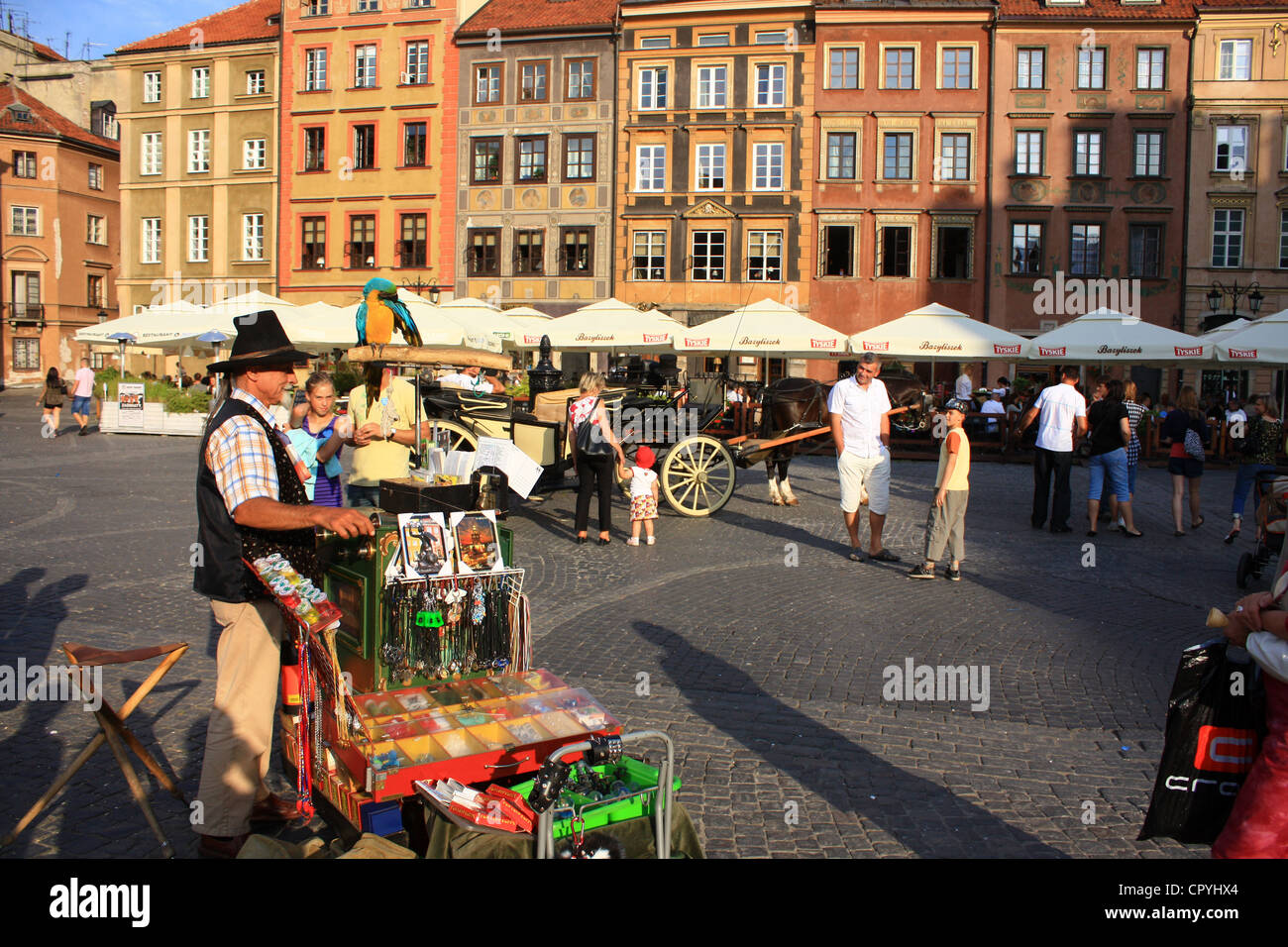 Life in Warsaw in the old town market square with organ grinder and crowd of people Stock Photo