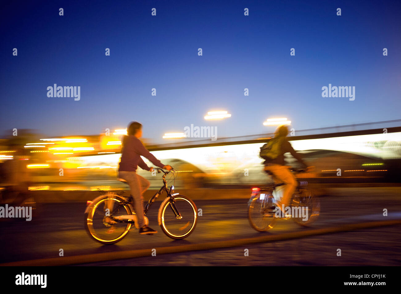 Panning shot of cyclists by Tirana Bridge, Seville, Spain Stock Photo