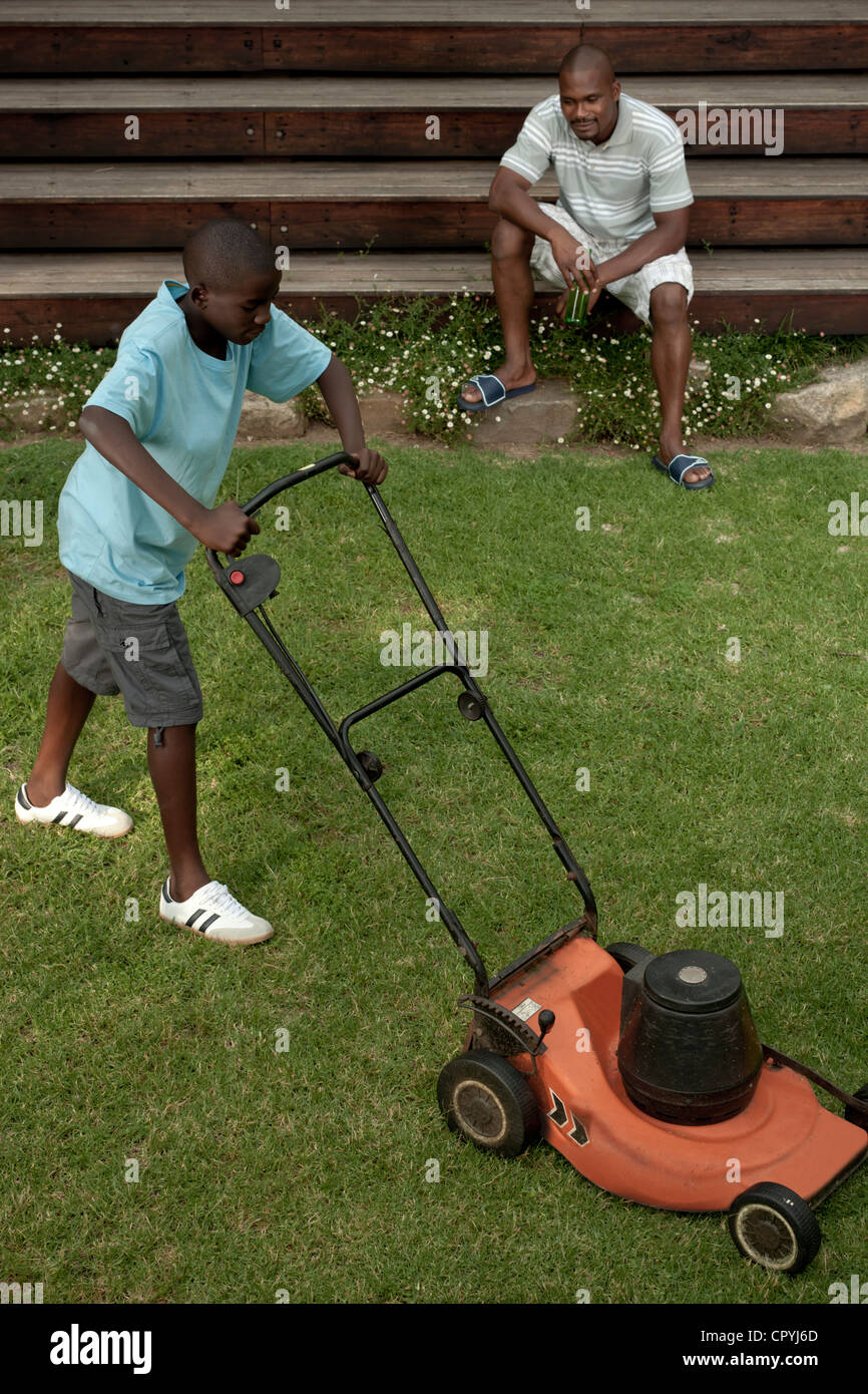 African boy mowing the lawn Stock Photo Alamy