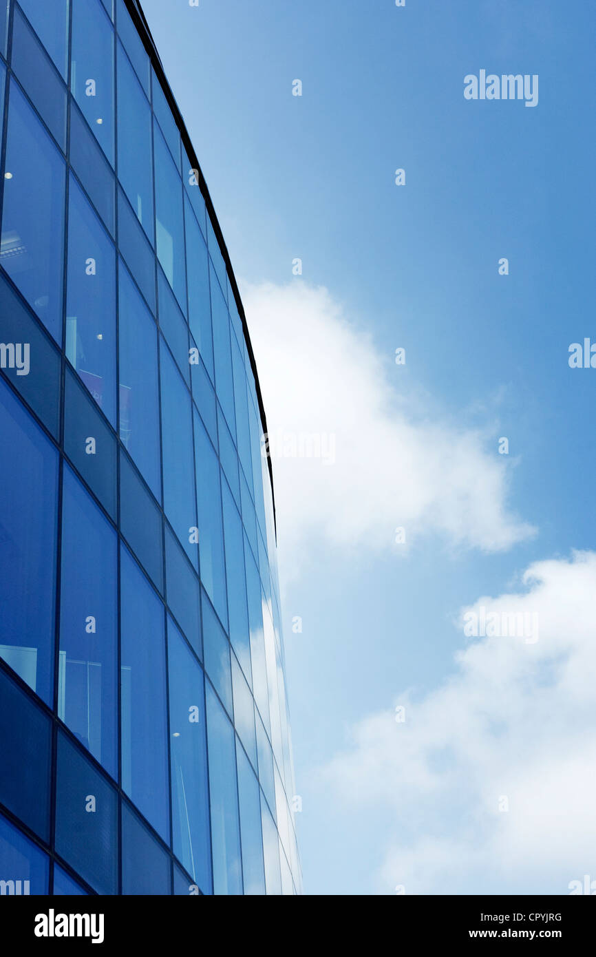 A glass fronted building photographed against a blue sky. Stock Photo