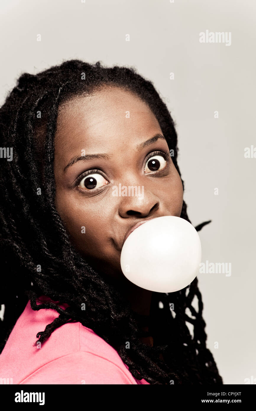 Portrait of a young black woman blowing a bubble with bubblegum Stock Photo