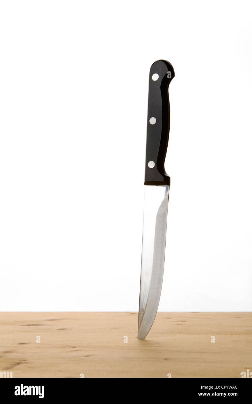 Kitchen knife stuck in a wooden table Stock Photo Alamy