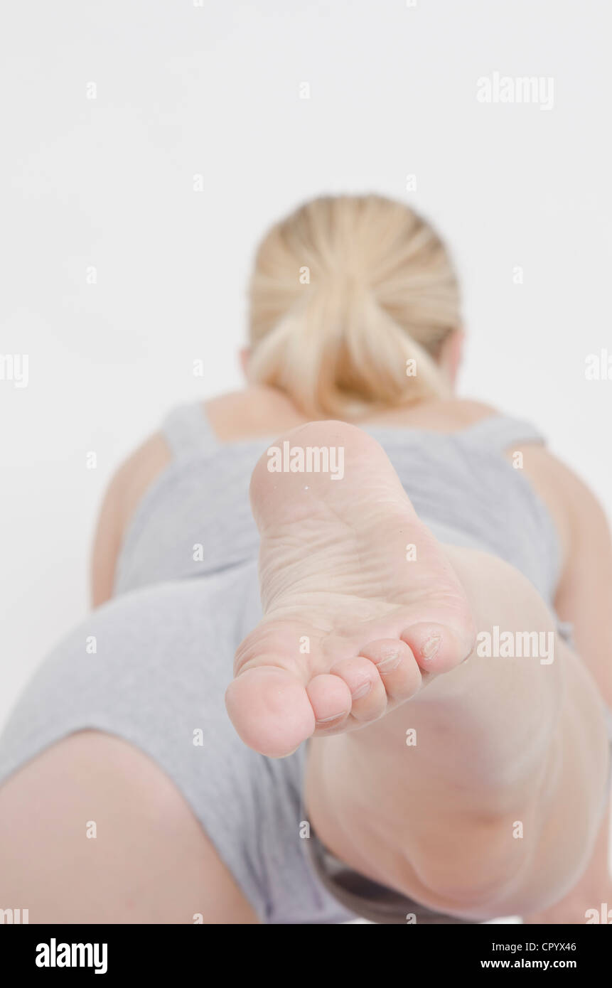 Young woman on all fours with her right leg stretched out behind her Stock Photo