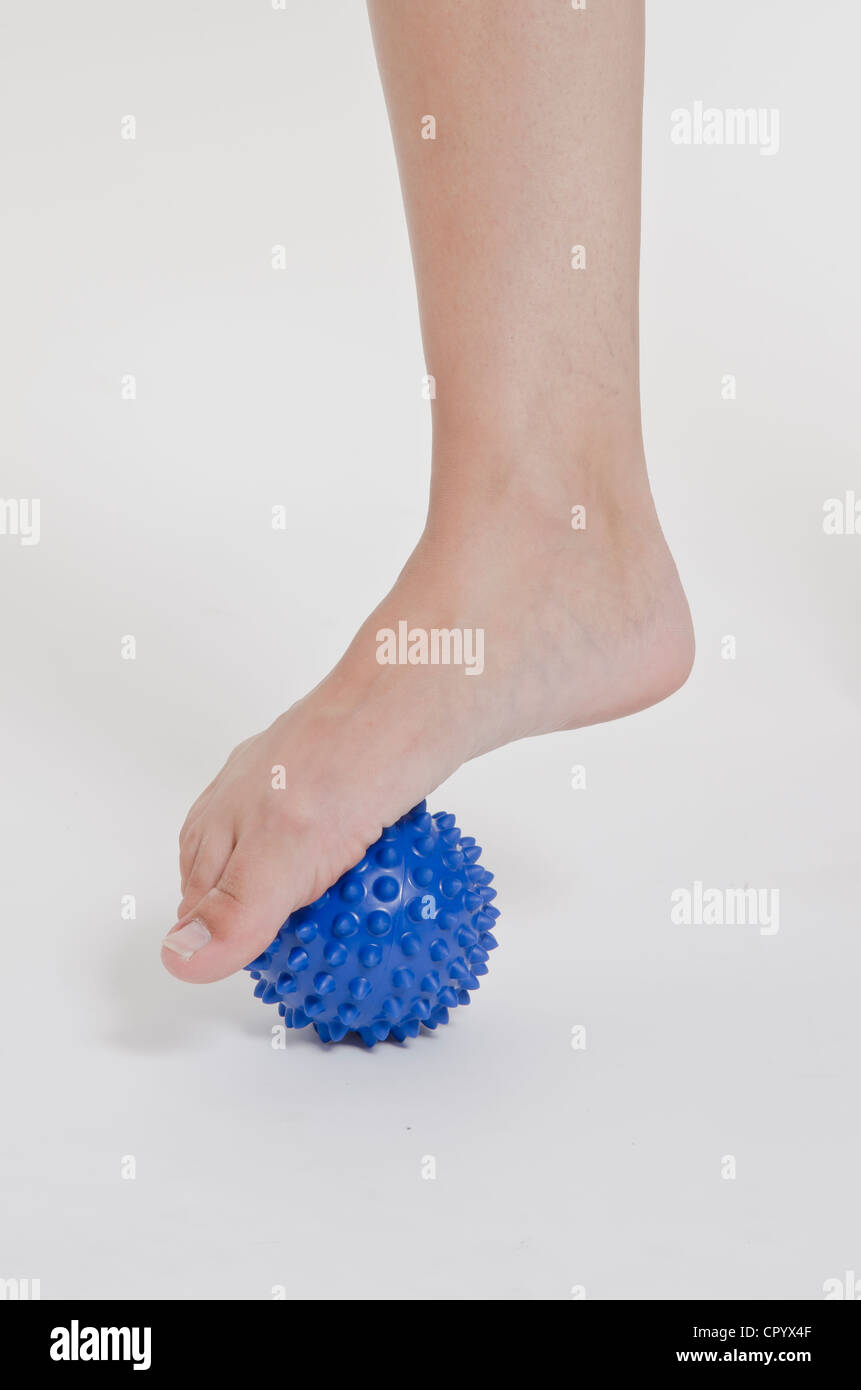 Woman with a blue spiky massage ball under her foot Stock Photo Alamy