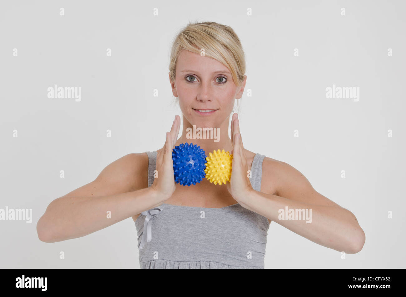 Young woman holding two spiky massage balls between her hands Stock