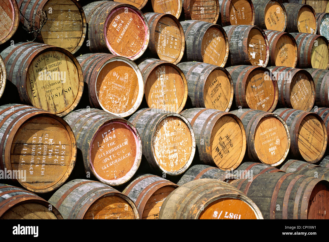 Empty whiskey barrels stacked outside distillery in Scotland Stock