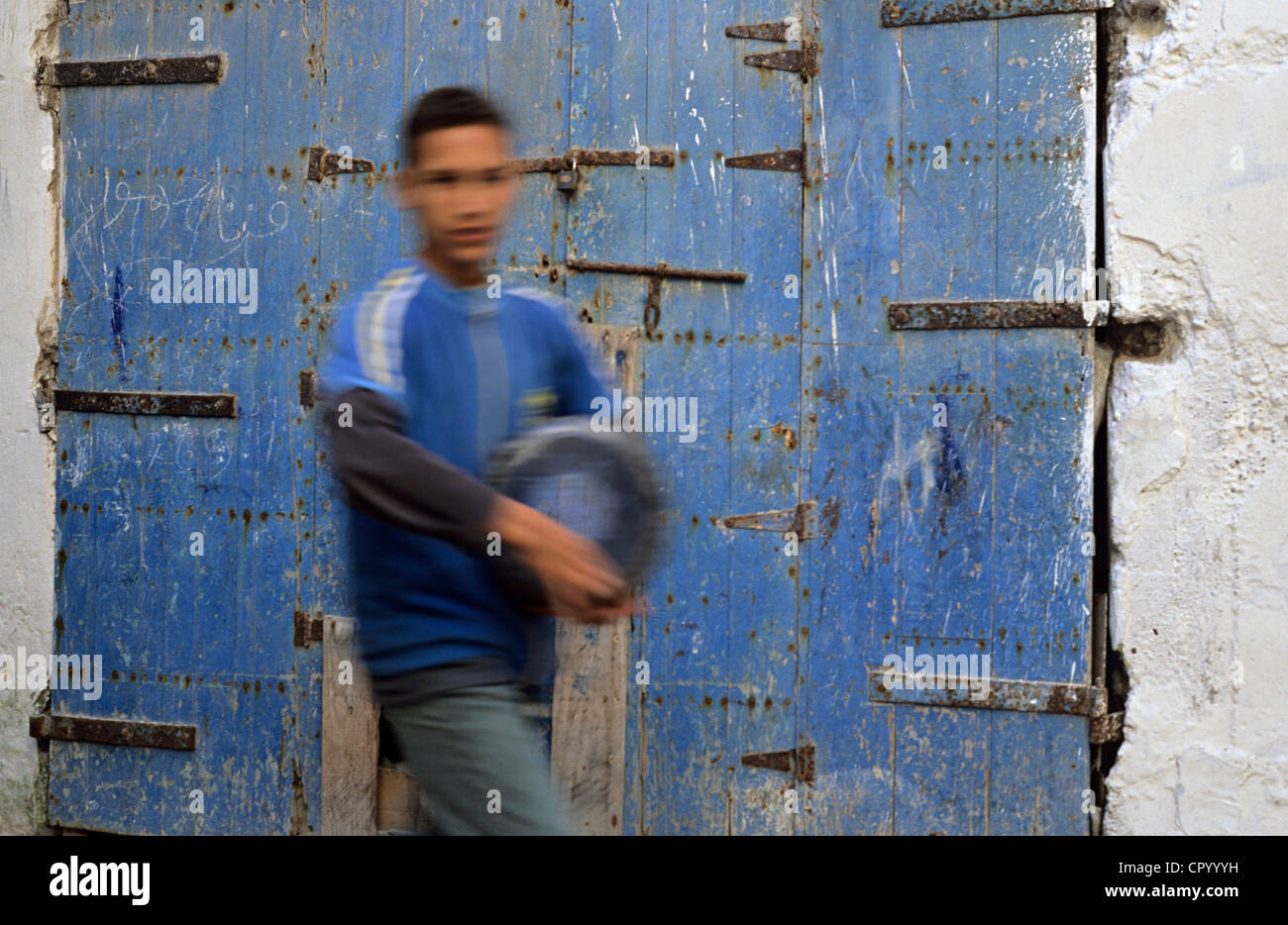 Morocco, Marrakech-Tensift-El Haouz Region, Essaouira, young man carrying a small drum Stock Photo