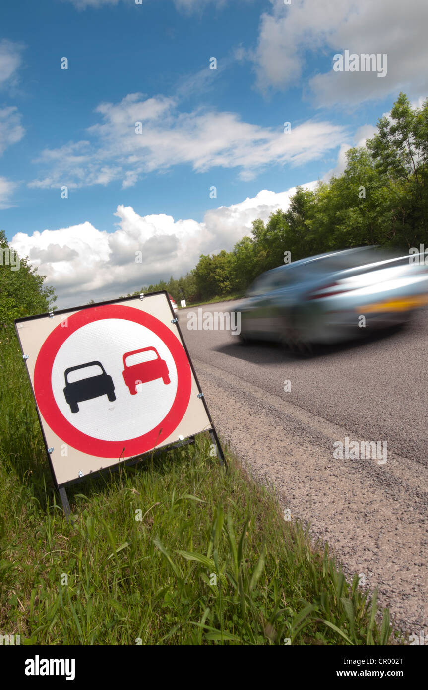 car passing no overtaking warning sign due to loose chippings on newly resurfaced road uk Stock Photo