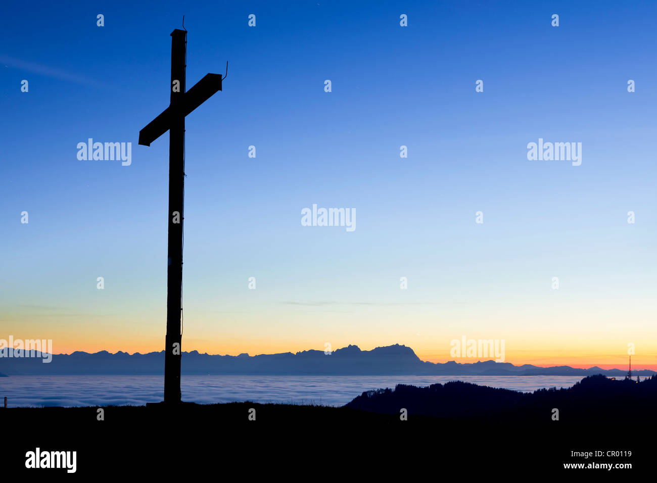 Evening view of the Alpstein mountains above the high fog, from Mt Hirschberg with summit cross, near Mt Pfaender, Austria Stock Photo