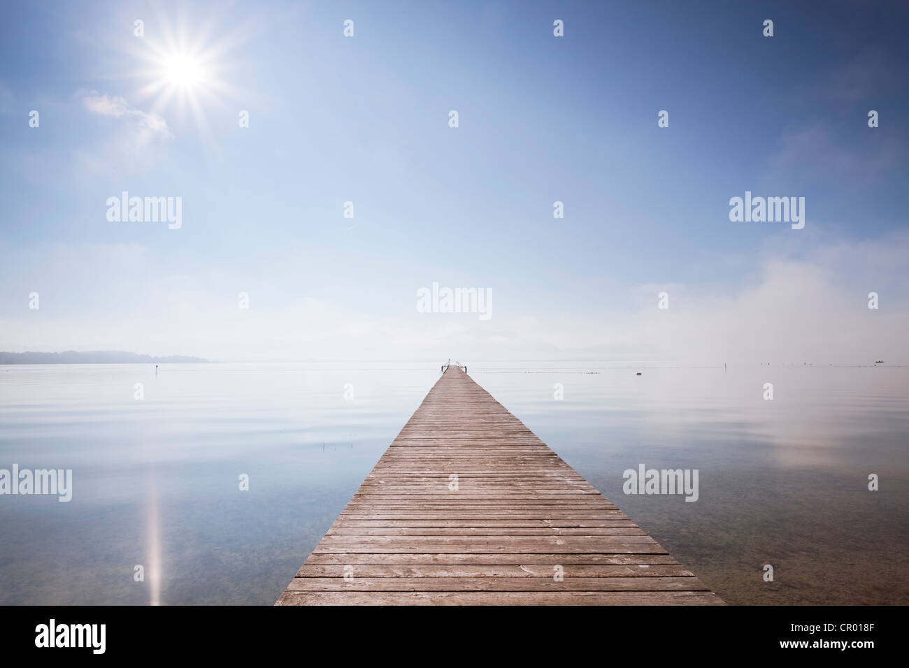 Very long jetty on Chiemsee Lake with high fog and sun near Seebruck, Bavaria, Germany, Europe, PublicGround Stock Photo