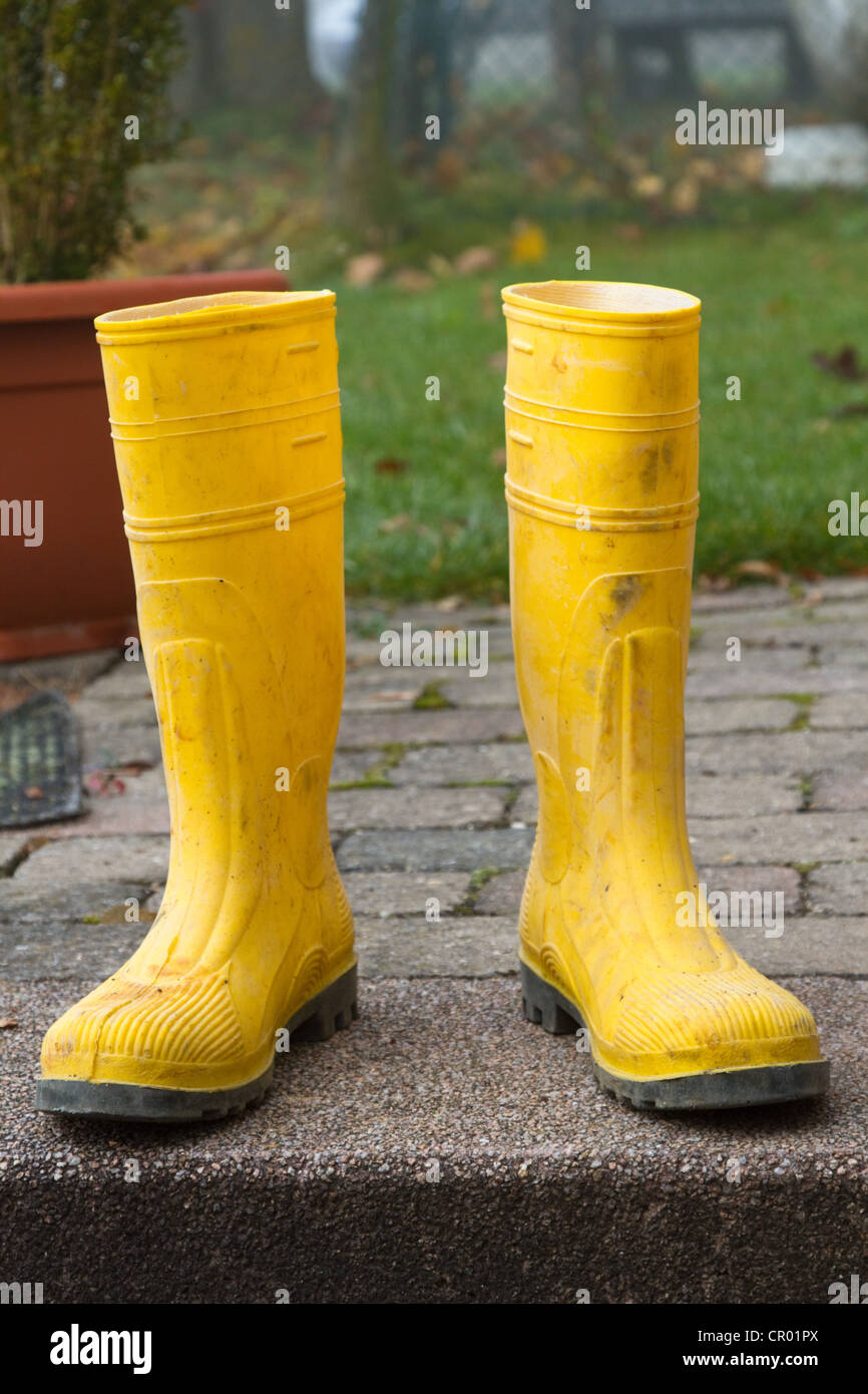 Pair of yellow rubber boots in the garden Stock Photo - Alamy