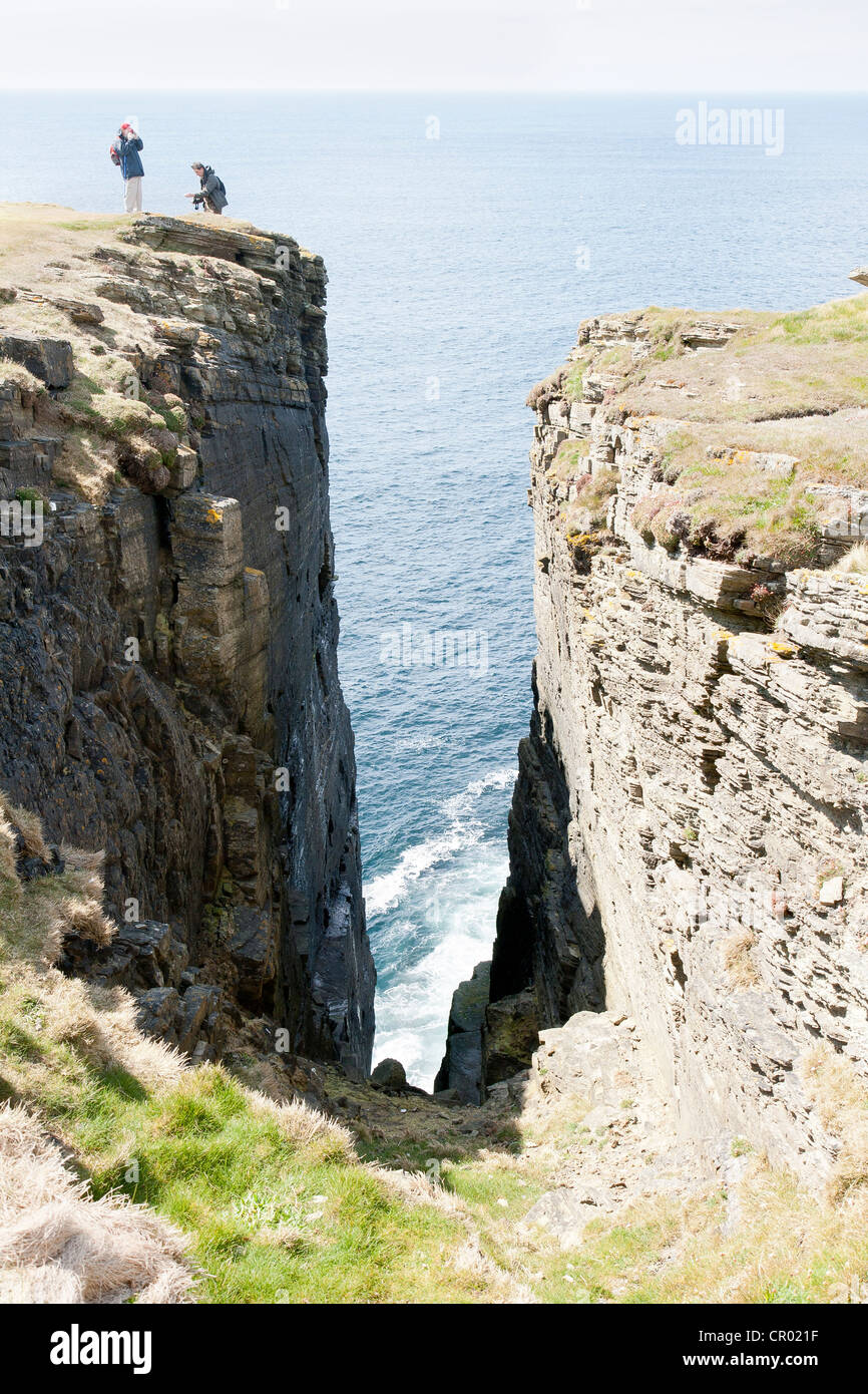 The brough of Birsay on the Orkney and men on a cliff Stock Photo