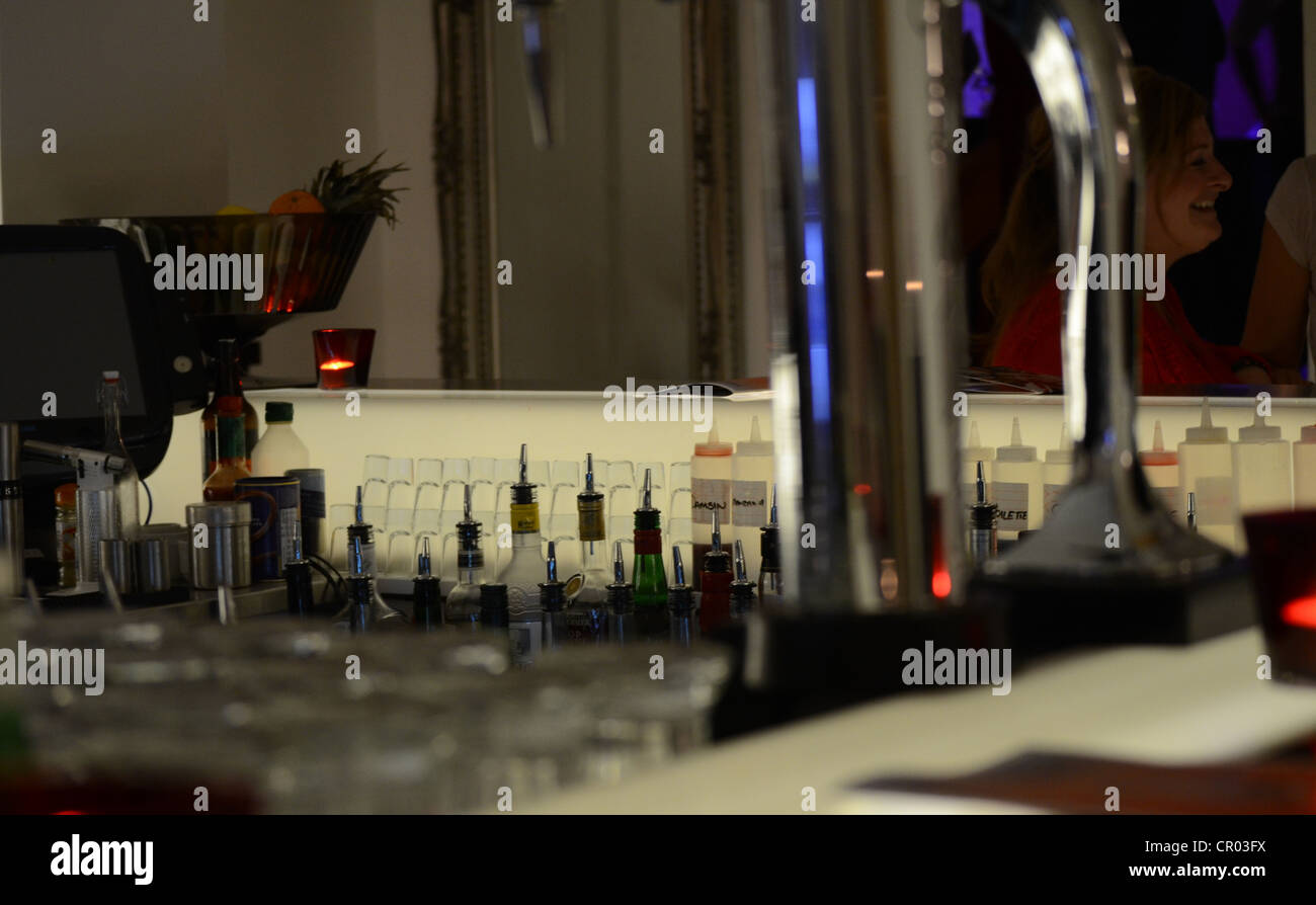 A view behind a bar of drink bottles and empty glasses Stock Photo